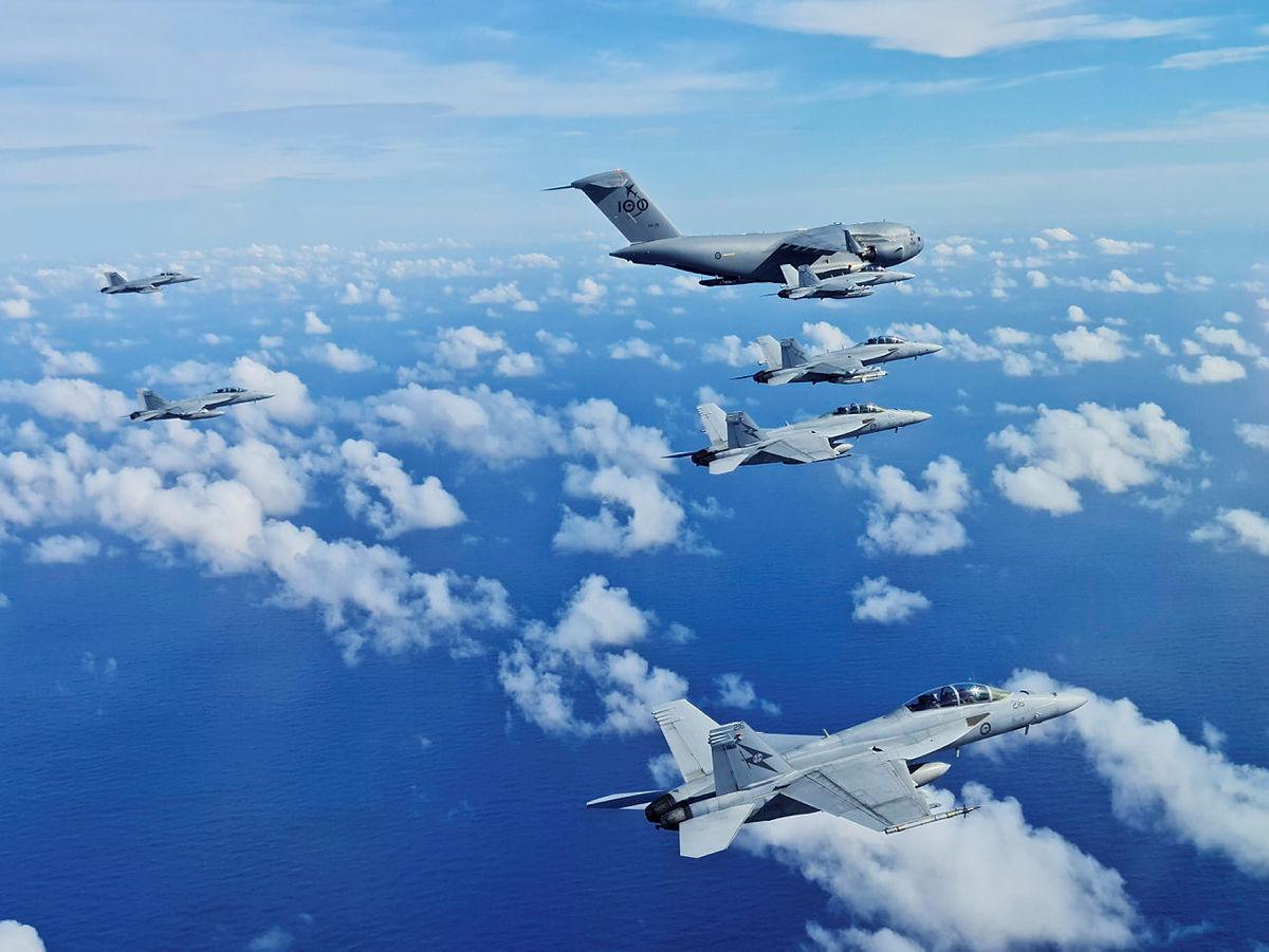 EA-18G Growlers from No. 6 Squadron and F/A-18F Super Hornets from No. 1 Squadron conduct air-to-air formation flying with a C-17A Globemaster III aircraft from No. 36 Squadron, off the coast of South East Queensland.