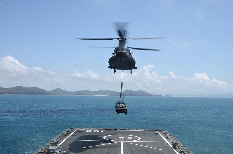 A CH-47D Chinook Heavy Lift Helicopter landing a Land Rover vehicle on the deck of RSS Persistence