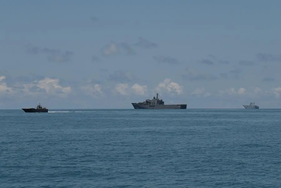 An FCU leaving from RSS Persistence (centre). To its right is the RAN's HMAS Adelaide.
