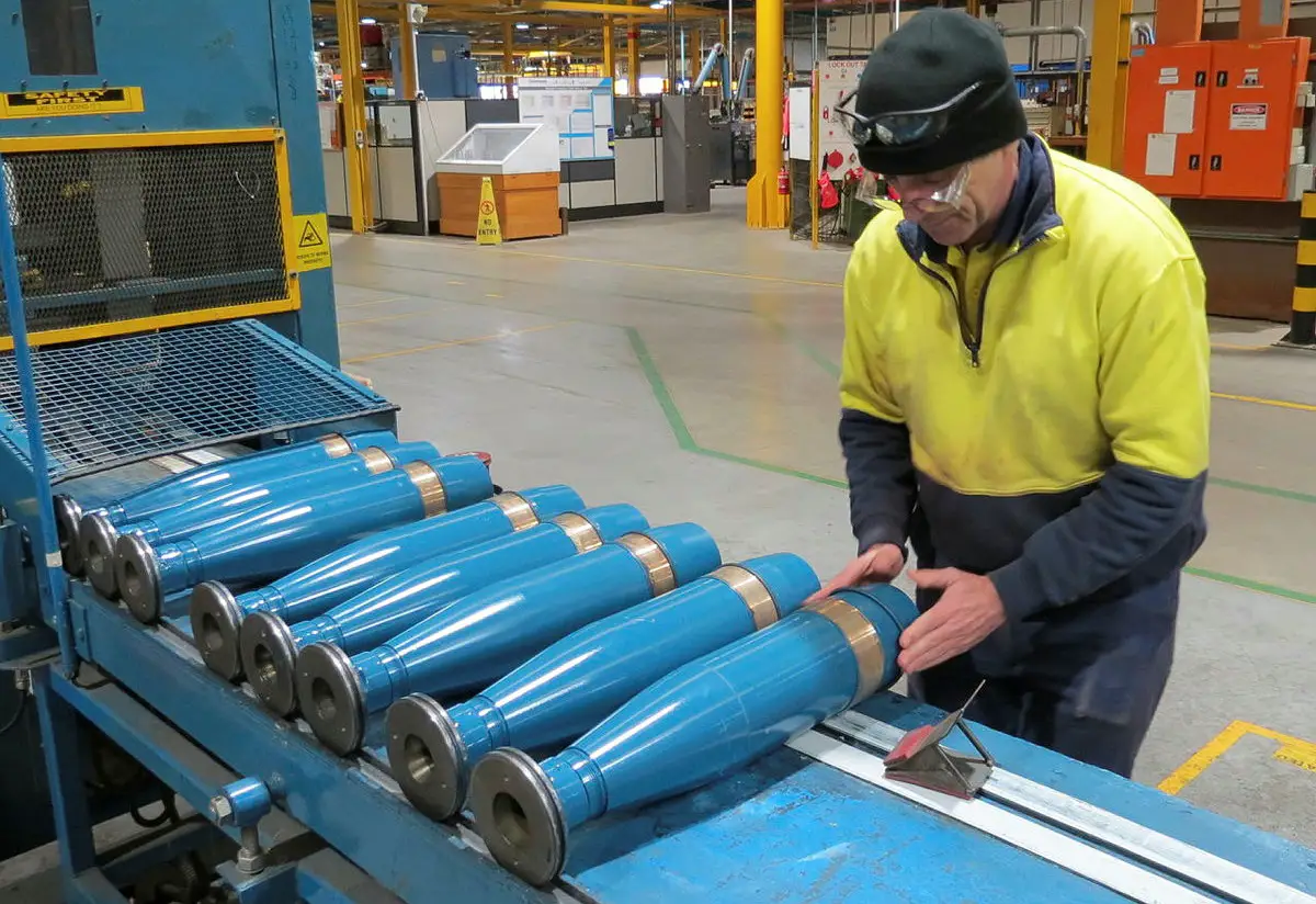 Thales Australia employee performs a visual inspection of artillery ammunitions at the end of the paint line at Benalla, VIC. 
