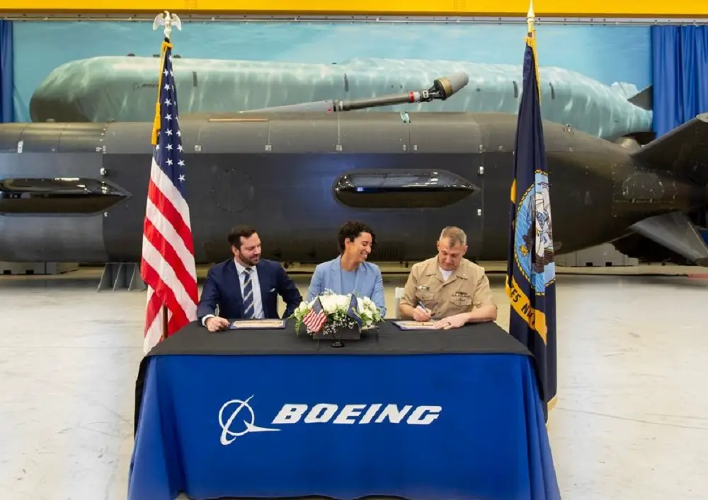Boeing’s Tracey Espero (center), program management director, signs over the first XLUUV Orca to U.S. Navy Capt. Edward Fultz (right), Unmanned Maritime Systems Fleet operations and testing project manager, and Joe Lazar (left), Navy XLUUV assistant program manager.