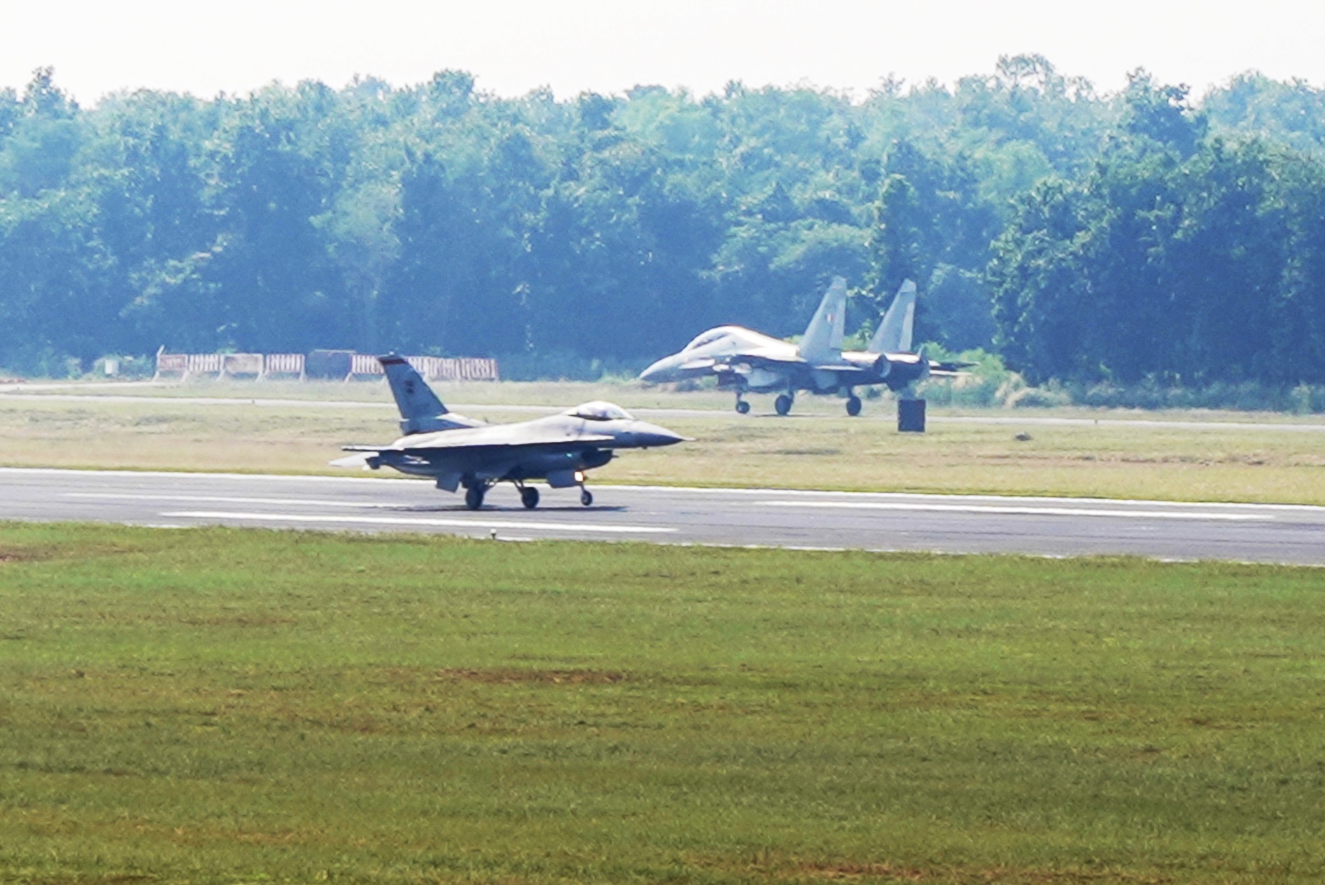An RSAF's F-16C (foreground) and an India Air Force's (IAF) SU-30MKI fighter aircraft (background) at the Kalaikunda Air Force Station runway before take-off as part of JMT 19. Photo courtesy: MIndef