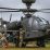 Petroleum Supply Specialists work together to refuel an Apache attack helicopter during training in FATCOW procedures.