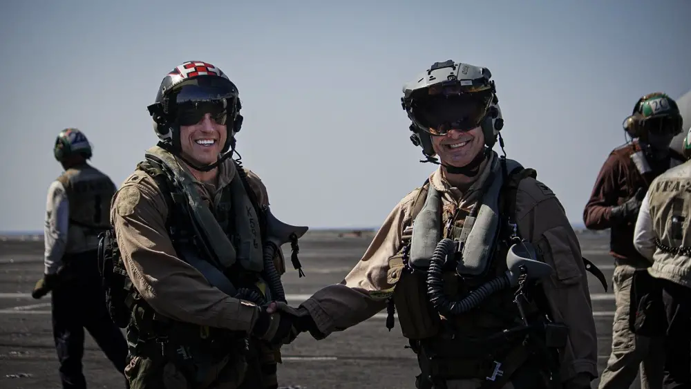 Cmdr. Kenneth Hockycko, commanding officer of the Fighting Checkmates of Strike Fighter Squadron (VFA) 211, left, shakes hands with Capt. Robert Gentry, commander, Carrier Air Wing (CVW) 1, on the flight deck of the aircraft carrier USS Harry S. Truman (CVN 75) after Gentryâ„¢s 1,200th career arrested landing in the Arabian Sea Feb. 1, 2020.