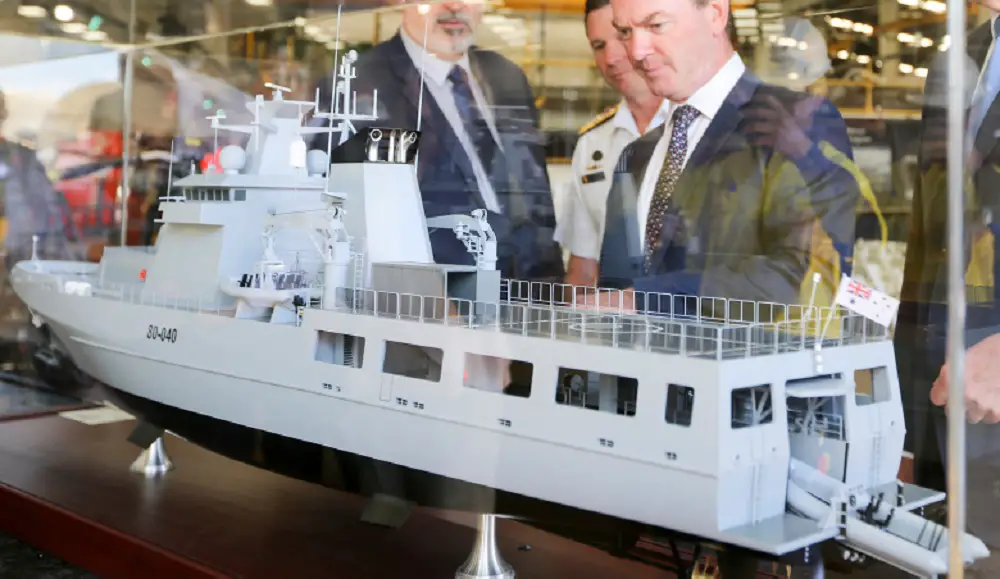 Minister for Defence, the Hon Christopher Pyne, MP (centre) inspects a model of the Arafura class offshore patrol vessel, at Osborne Naval Shipyard in Adelaide.