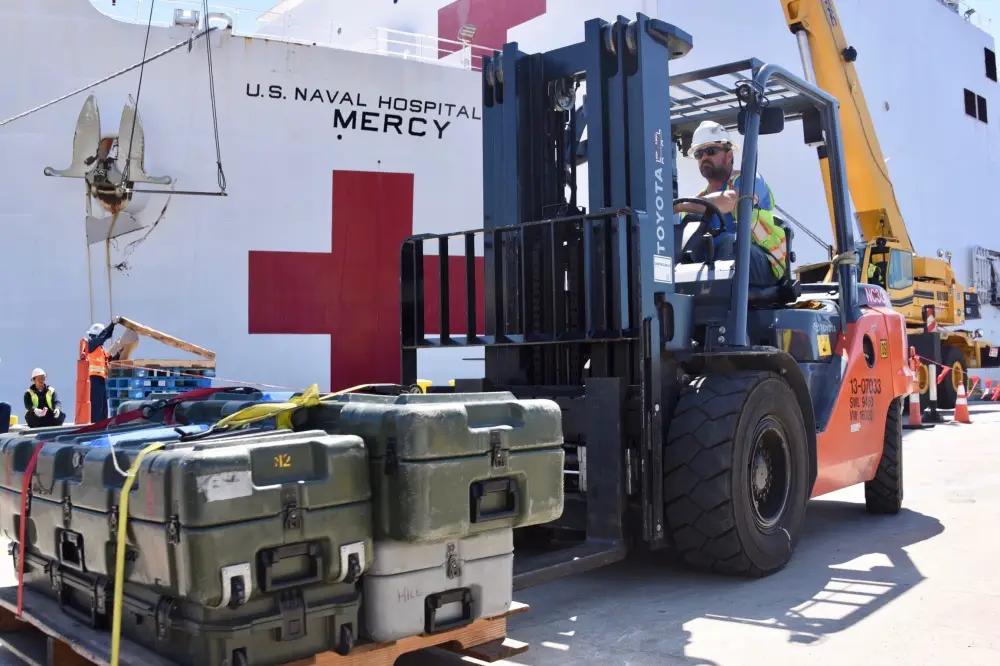 Naval Facilities Engineering Command Southwest forklift driver Steve King moves pallets of supplies to be craned aboard Military Sealift Command hospital ship USNS Mercy (T-AH 19) at Naval Base San Diego, March 21, 2020. 
