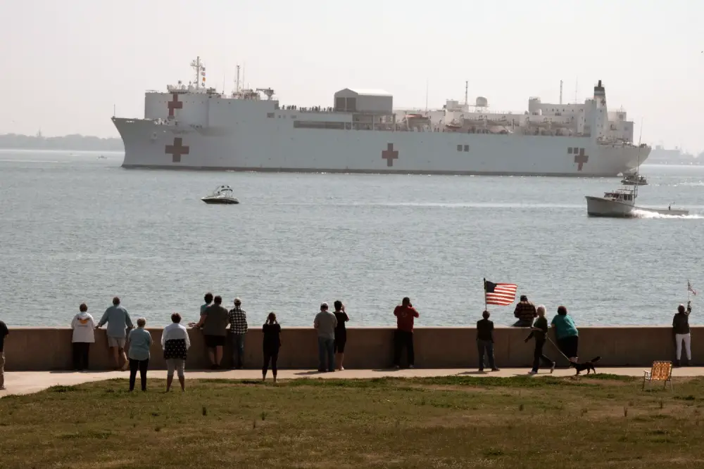 People gather to watch the Military Sealift Command hospital ship USNS Comfort (T-AH 20) depart Naval Station Norfolk, Va. March 28, 2020. (U.S. Navy photo by Mass Communication Specialist 1st Class Joshua D. Sheppard)