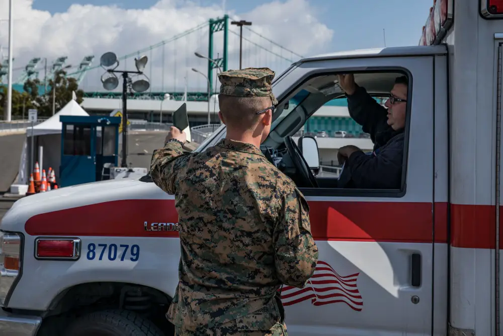 U.S. Marine Corps guides an ambulance toward the Military Sealift Command hospital ship USNS Mercy (T-AH 19) in Los Angeles. (U.S. Marine Corps photo by Cpl. Alexa M. Hernandez/Released)