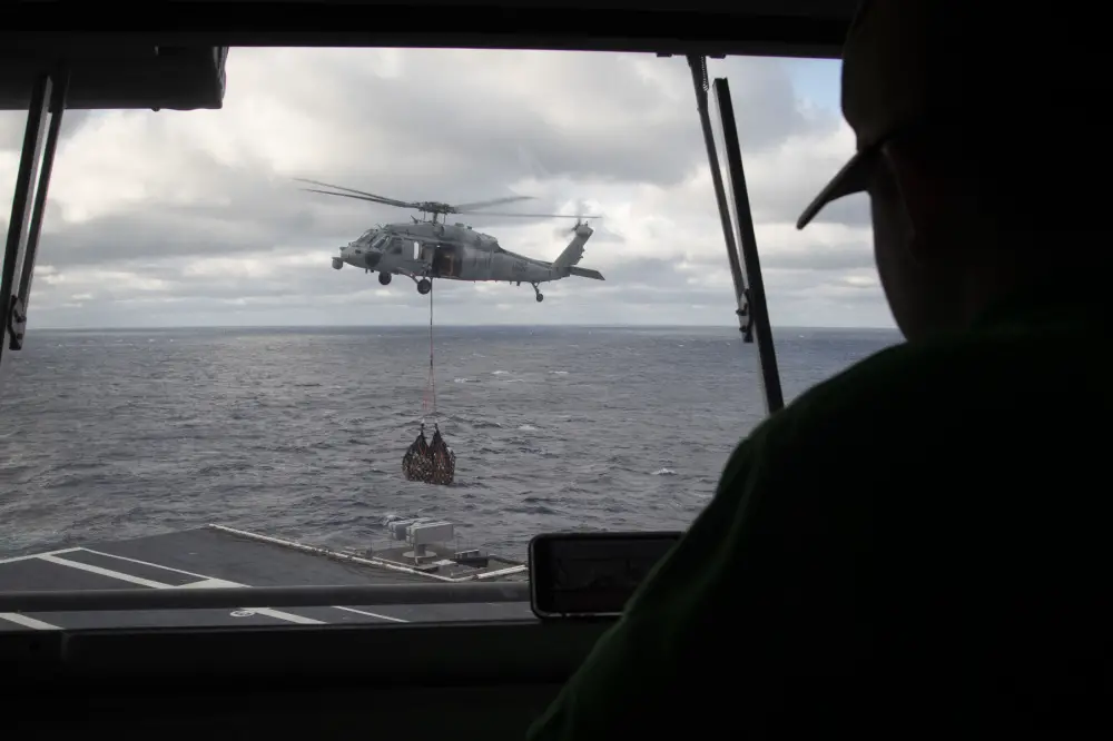 Logistics Specialist 2nd Class Samuel Muzzio, from Newnan, Georgia, assigned to USS Gerald R. Ford's (CVN 78) supply department, observes an MH-60S Sea Hawk helicopter, attached to Helicopter Sea Combat Squadron (HSC) 9, from the pilot house during a vertical replenishment-at-sea with USNS Joshua Humphreys (T-AO 188) March 24, 2020. Ford is underway in the Atlantic Ocean conducting carrier qualifications. (U.S. Navy photo by Mass Communication Specialist 3rd Class Brett Walker)