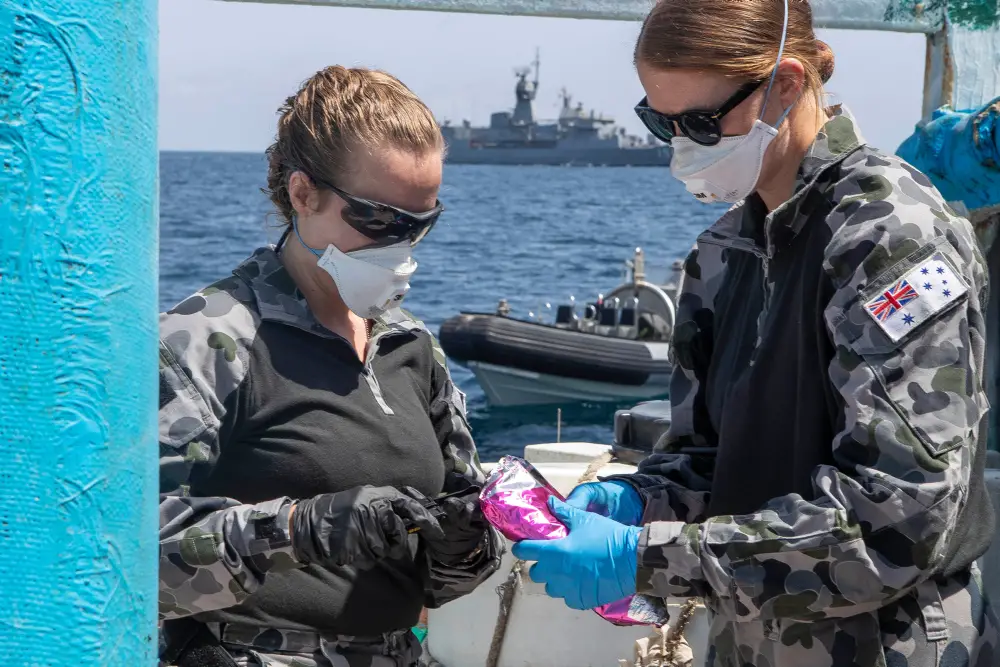 Lieutenant Maree Altham, left, and Lieutenant Shannen Rowe from HMAS Toowoomba conduct tests on a parcel discovered after boarding and searching a dhow in the Gulf of Aden as part of Operation MANITOU on 19 March 2020.