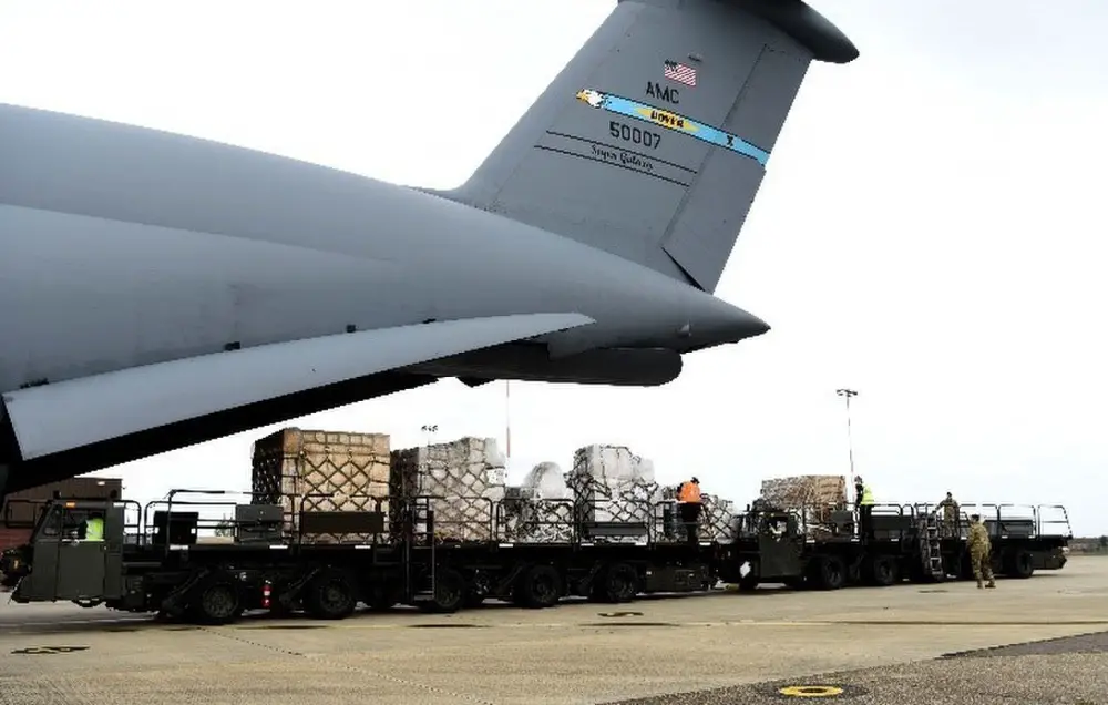 Air mobility Airmen and contractors from the 727th Air Mobility Squadron, RAF Mildenhall, England, push pallets of cargo onto a K-loader off of a C-5 Super Galaxy assigned to the 9thAirlift Squadron, Dover Air Force Base, Delaware, during a medical cargo mission at RAF Mildenhall, England, April 18, 2020. The 727th MS and 9th AS took part in a mission which involved delivering COVID-19 test kits and other equipment to Accra, Ghana, to be distributed throughout the U.S. African Command area of responsibility. (U.S. Air Force photo by Senior Airman Brandon Esau)