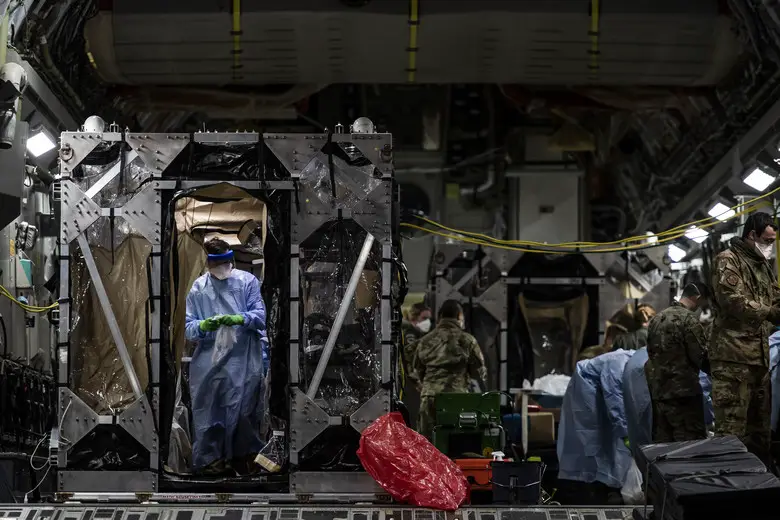 U.S. Air Force Airmen aboard a C-17 Globemaster III begin disinfecting and decontaminating the aircraft after the first-ever operational use of the Transport Isolation System at Ramstein Air Base, Germany, April 10, 2020. The TIS is an infectious disease containment unit designed to minimize contamination risk to aircrew and medical attendants, while allowing in-flight medical care for patients afflicted by a diseaseâ€”in this case, COVID-19. (U.S. Air Force photo by Staff Sgt. Devin Nothstine)