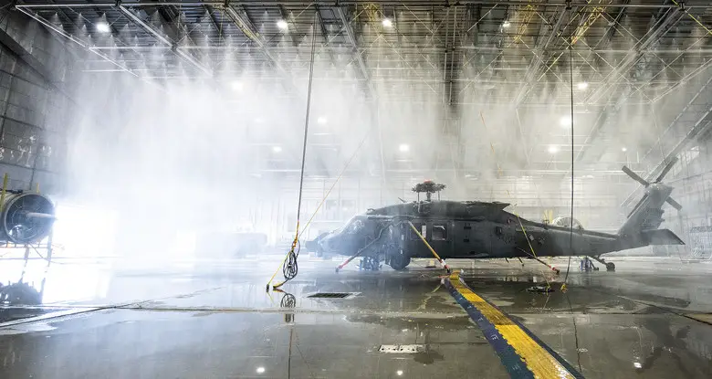An HH-60W Jolly Green gets hit with 45 mph winds and drenched under 130 gallons-per-minute rain in the McKinley Climatic Lab April 1 at Eglin Air Force Base, Fla.  The Air Force's new search and rescue helicopter and crews experienced temperature extremes from 120 to -60 degrees Fahrenheit as well as torrential rain during the month of testing.  The tests evaluate how the aircraft and its instrumentation, electronics and crew fare under the extreme conditions it will face in the operational Air Force.  (U.S. Air Force photo/Samuel King Jr.)
