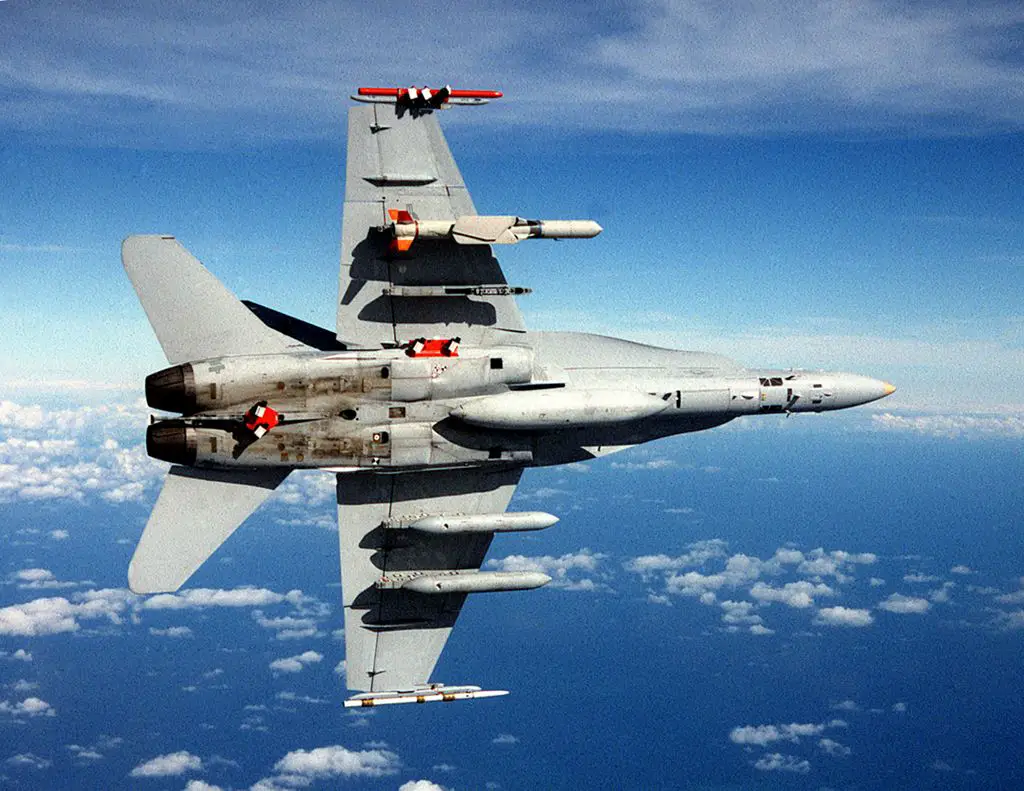 A U.S. Navy McDonnell Douglas F/A-18C Hornet from the Naval Air Warfare Center, Weapons Division (NAWCWD), China Lake, California (USA), in flight. The aircraft is equipped with an AGM-84 Standoff Land Attack Missile-Expanded Response (SLAM-ER) under the right wing and two AN/AWW-13 Advanced Data Link pods under the left wing.