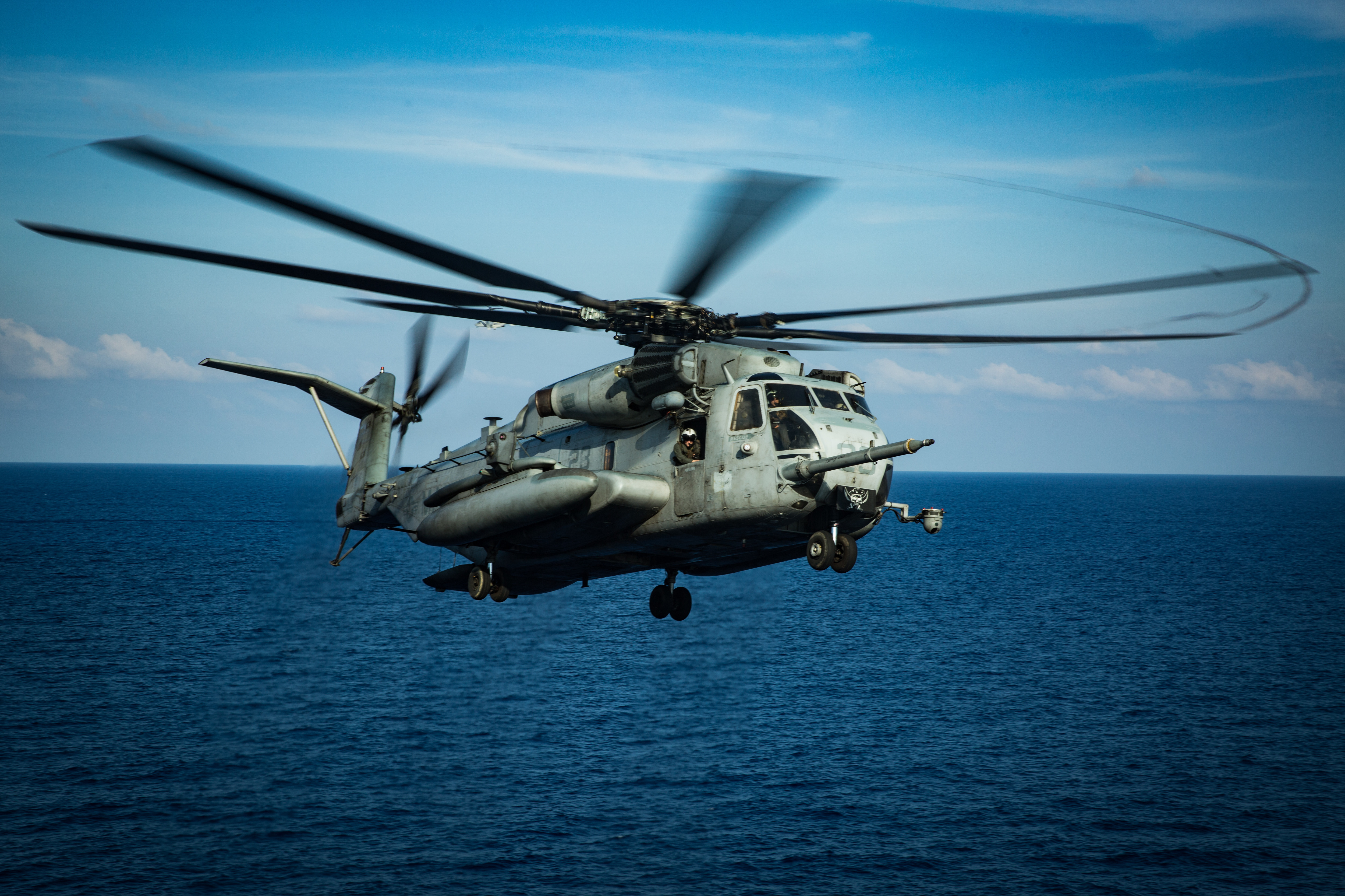 A CH-53E Super Stallion helicopter with Marine Medium Tiltrotor Squadron (VMM) 265 (Reinforced), 31st Marine Expeditionary Unit (MEU), lands on the flight deck of amphibious assault ship USS America (LHA 6) during flight operations. Marines and Sailors aboard the America regularly conduct flight operations while underway to maintain their readiness to respond to contingencies. America, flagship of the America Expeditionary Strike Group, 31st MEU team, is operating in the U.S. 7th Fleet area of operations to enhance interoperability with allies and partners and serve as a ready response force to defend peace and stability in the Indo-Pacific region. (U.S. Marine Corps photo by Sgt. Audrey M. C. Rampton)