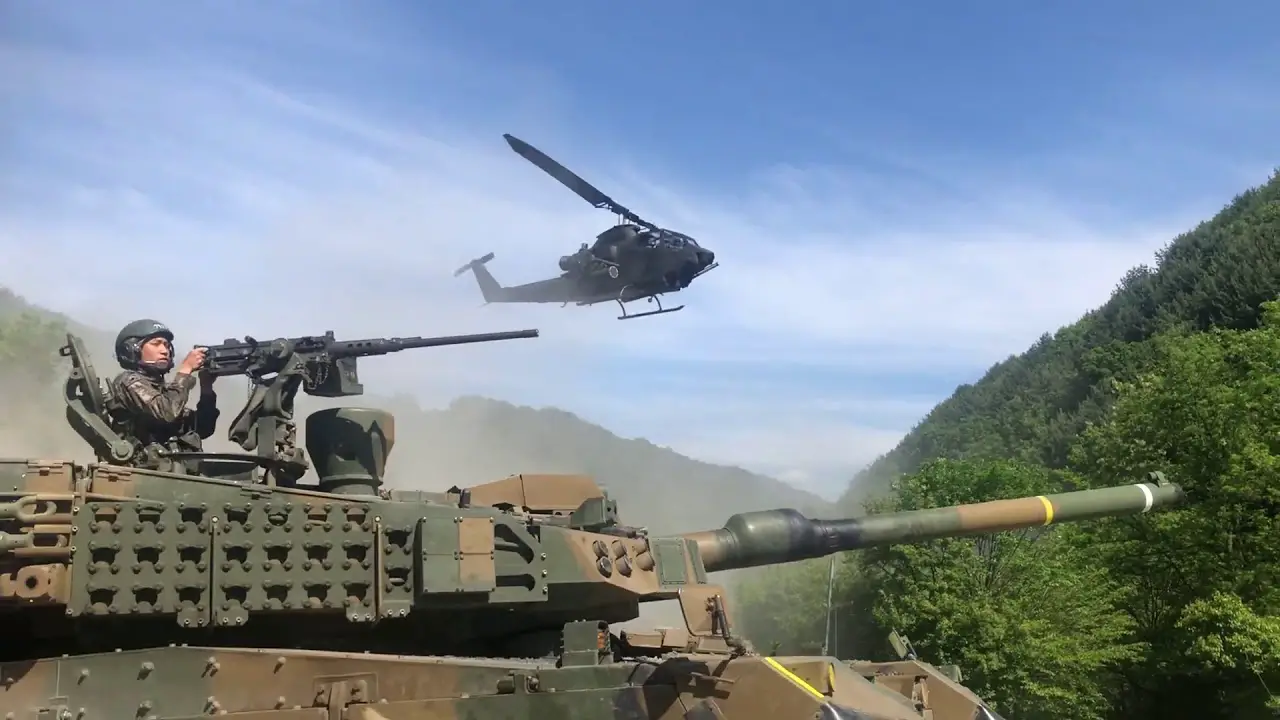 Republic of Korea Army AH-1S Cobra attack helicopters provide air cover for K2 Black Panther main battle tanks.