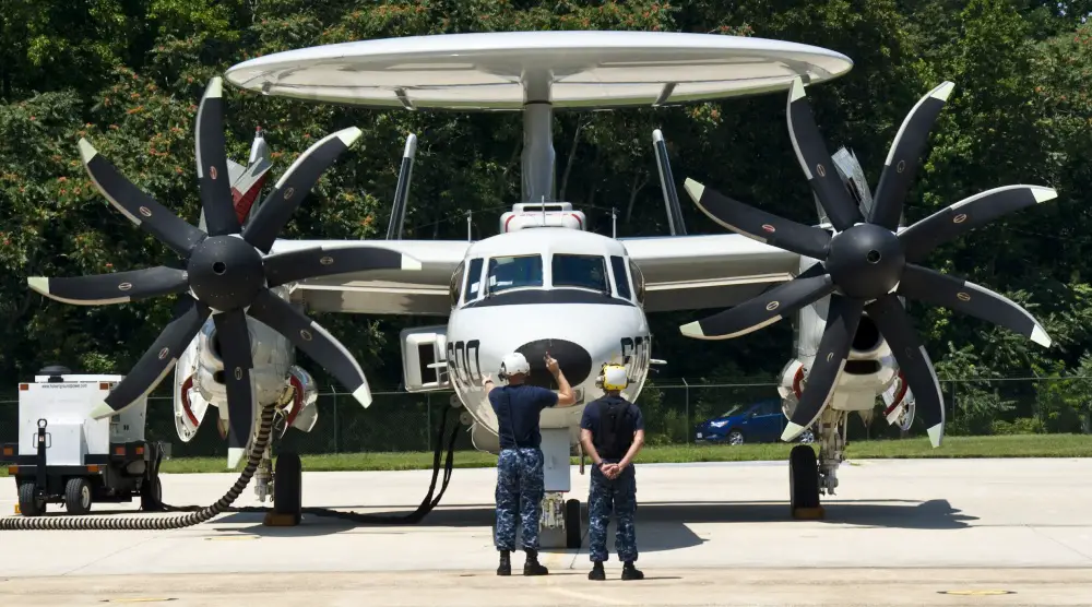 Aviation Structural Mechanic 1st Class Stephen Swett, left, and Airman Armando Braddy, assigned to the Pioneers of Air Test and Evaluation Squadron (VX) 1, signal for the start up of an E-2D Hawkeye on the flight line. (U.S. Navy photo by Mass Communication Specialist 2nd Class Kenneth Abbate/Released)