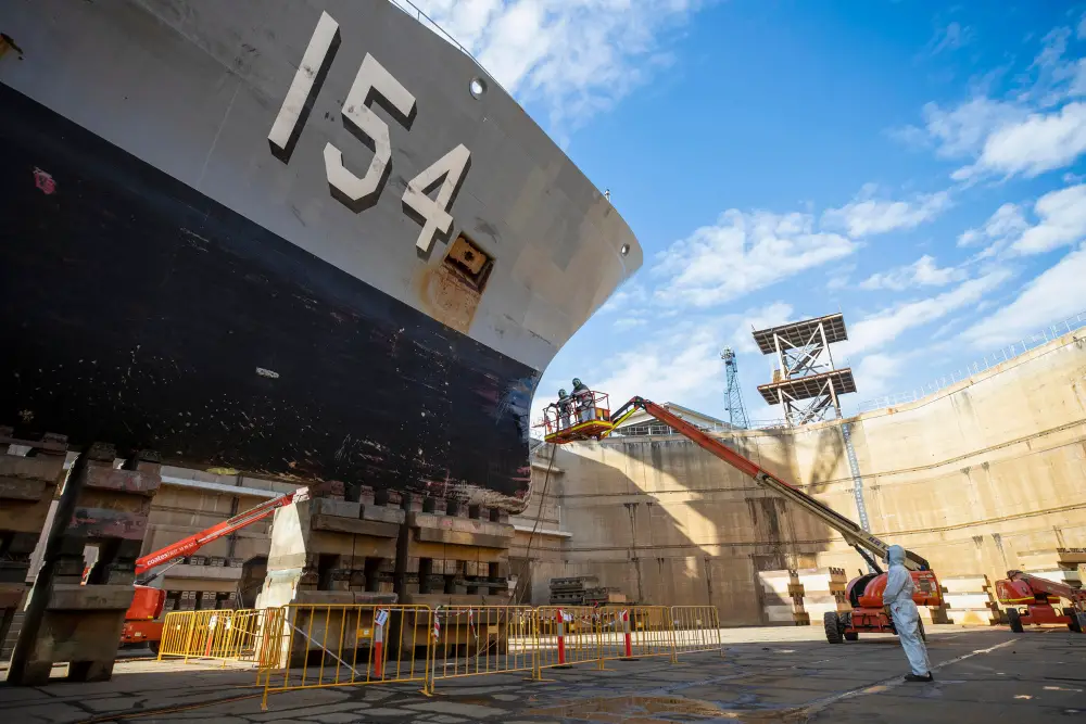 Defence contractors conduct maintenance on HMAS Parramatta during her refit in the Captain Cook Graving Dock at Garden Island, Sydney, NSW.