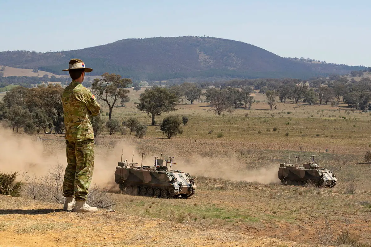 Australian Army officer Brigadier Ian Langford, DSC and Bars, watches on as two autonomous M113 AS4 optionally crewed combat vehicle (OCCV) assault an enemy position at the Majura Training Area, Canberra.