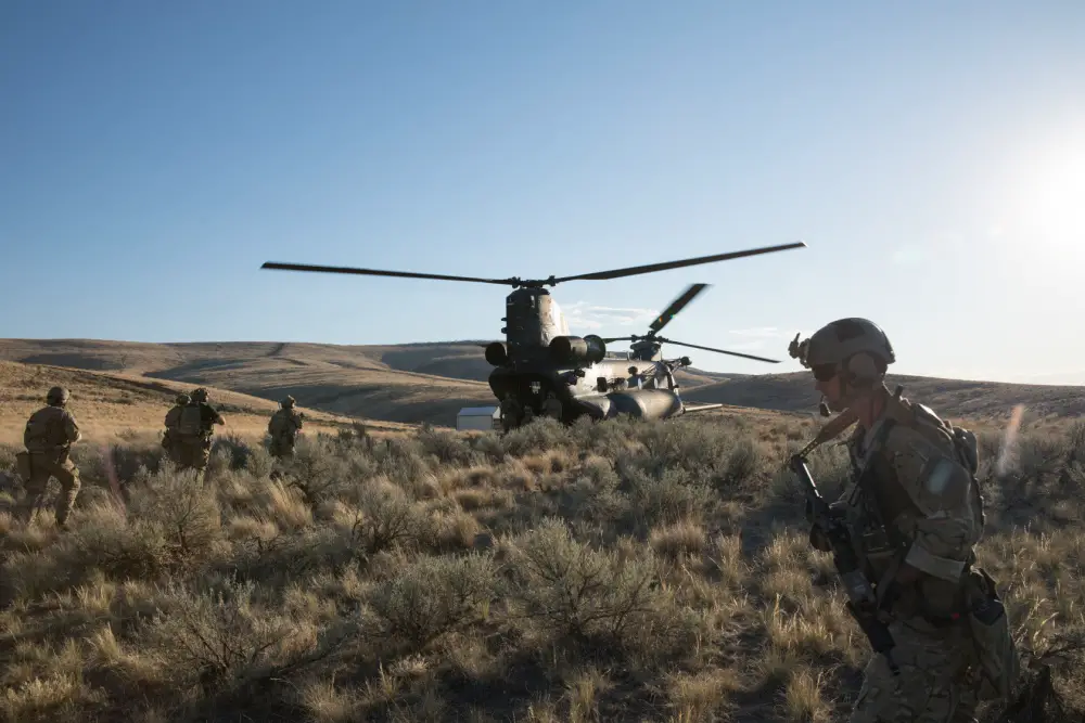  Green Berets and special operations forces enablers with 1st Special Forces Group (Airborne) load into an MH-47 Chinook helicopter at Yakima Training Center, Washington.