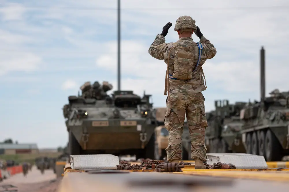 Staff Sgt. Shawn Mercer, a cavalry scout assigned to Alpha Troop, 4th Squadron, 10th Cavalry Regiment, 3rd Armored Brigade Combat Team, 4th Infantry Division, guides a Stryker onto a railcar at Fort Carson, Colorado,