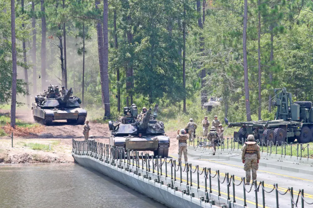 M1 Abrams Tank crews from 3rd Battalion, 69th Armored Regiment, 1st Armored Brigade Combat Team, 3ID, maneuver their tanks over an improved ribbon bridge, July 17, 2020, during a wet gap crossing exercise at Pineview Lake, Fort Stewart, Georgia.