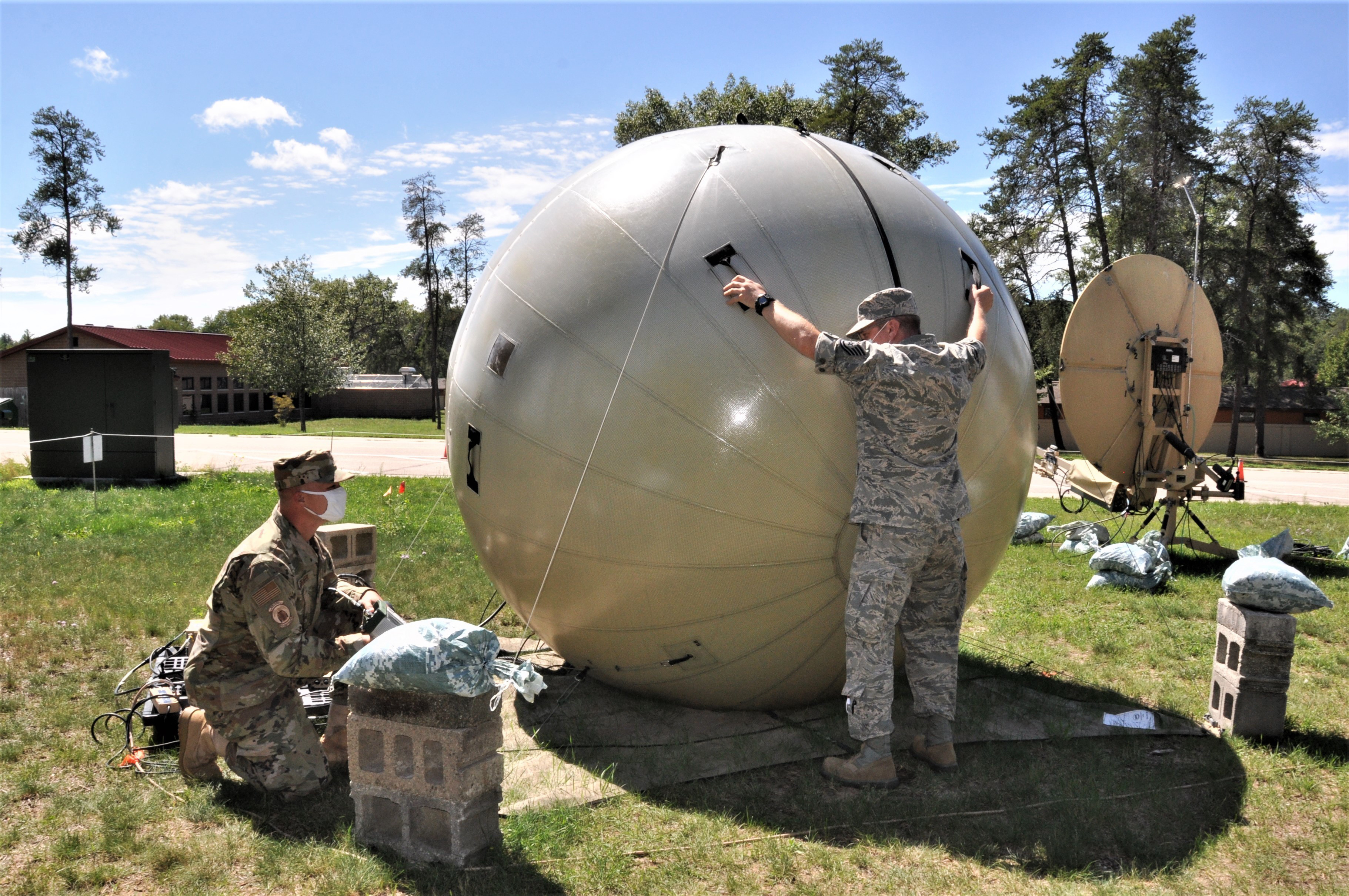 The radio frequency transmission specialists with the 271st Combat Communications Squadron, Pennsylvania Air National Guard, manually adjust a satellite system attached to a small-scale communications suite, in order to provide the strongest possible signal at the Alpena Combat Readiness Training Center.