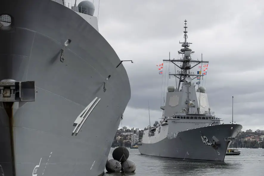 Royal Australian Navy HMAS Sydney passes sister ship HMAS Brisbane as they depart Garden Island in Sydney.