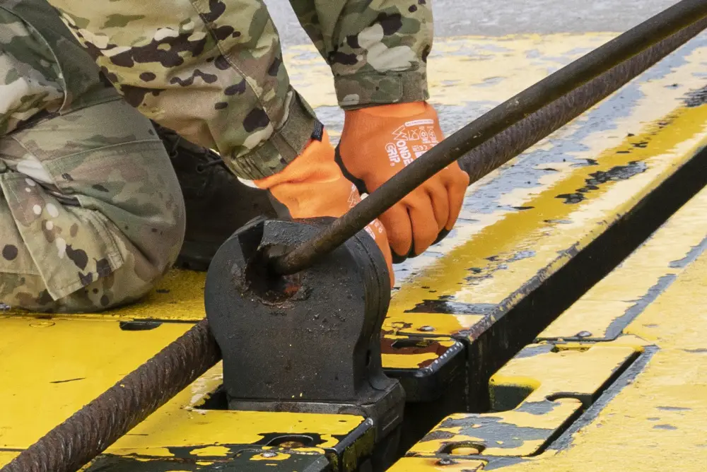 U.S. Air Force Airman 1st Class Chelsea Glasscock, 435th Construction and Training Squadron Aircraft Arresting System Depot apprentice, returns the system to its starting position during a Barrier Arresting Kit certification at Ã„mari AB, Estonia, March 17, 2021.