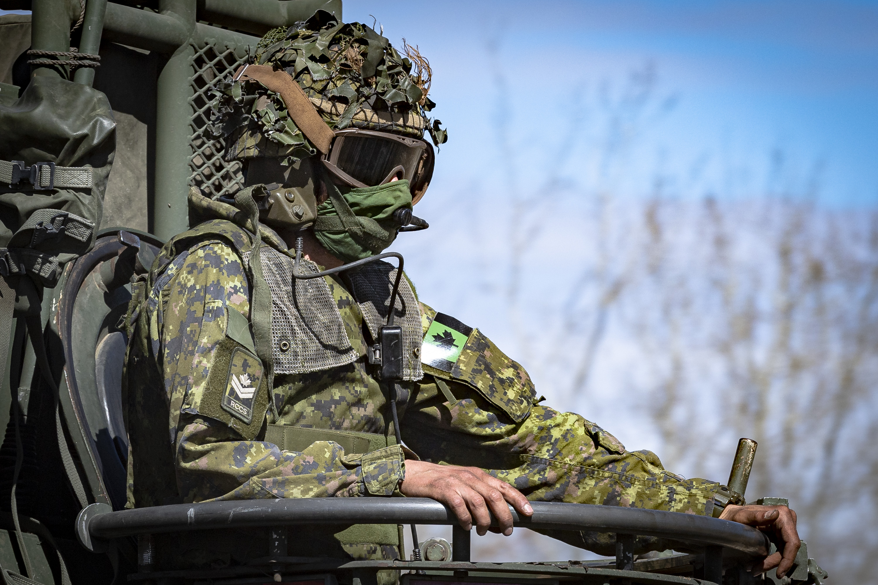 A Master Corporal from the Royal Canadian Corps of SignalsÂ rides on a Light Armoured Vehicle (LAV) III while in the training area at 3rd Canadian Division Support Base Garrison Wainwright in preparation for Exercise MAPLE RESOLVE 21 on April 30, 2021. 