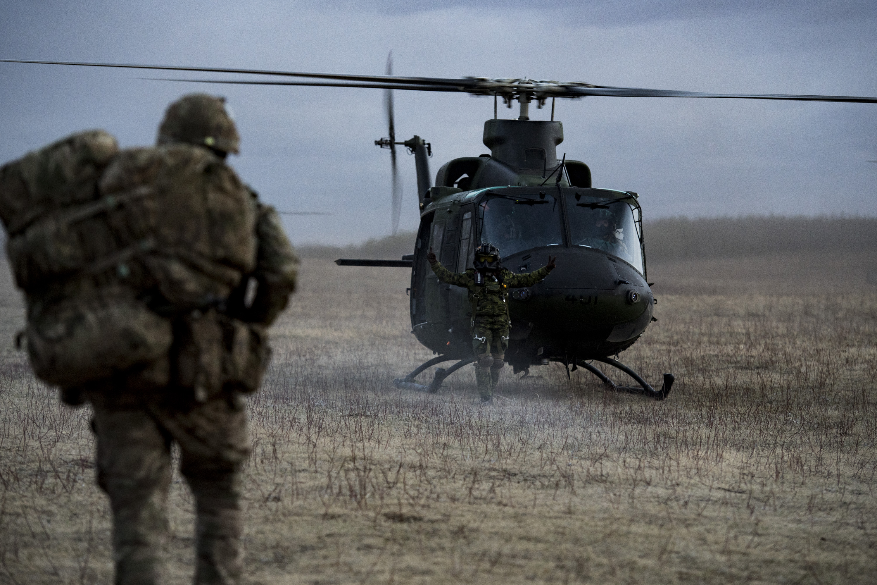  A Flight Engineer from a CH-146Â GriffonÂ Helicopter directs members of the British Army 1st Battalion, The Rifles during Exercise MAPLE RESOVE.