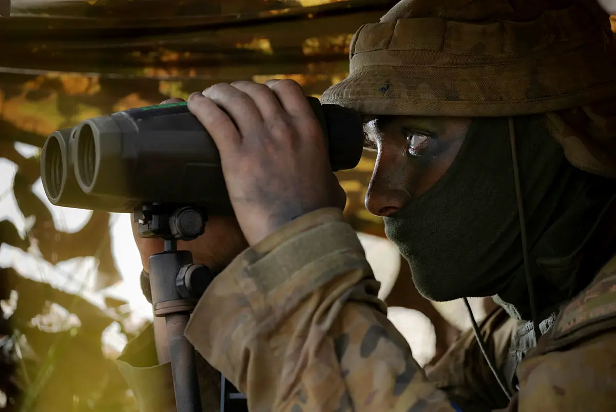 Australian Army Gunner Elliott Ryan from the 4th Regiment, Royal Australian Artillery, observes the target during Exercise Chau Pha at Townsville Field Training Area on 22 May 2021.