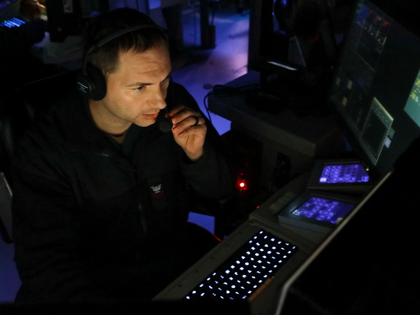 Operations Specialist 1st Class Justin Brown, from Albany, N.Y., monitors the surface and air picture from inside the combat information center aboard Arleigh Burke-class guided-missile destroyer USS Benfold (DDG 65) while conducting routine underway operations.