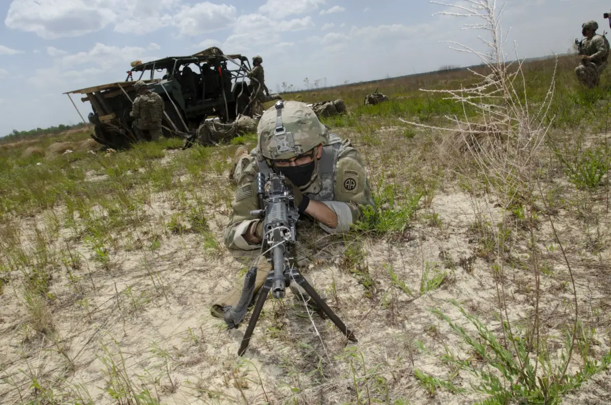 An Infantry Soldier performs perimeter guard as his fellow squad members de-rig the Infantry Squad Vehicle (ISV) on Holland Drop Zone, Fort Bragg, North Carolina during operational testing.