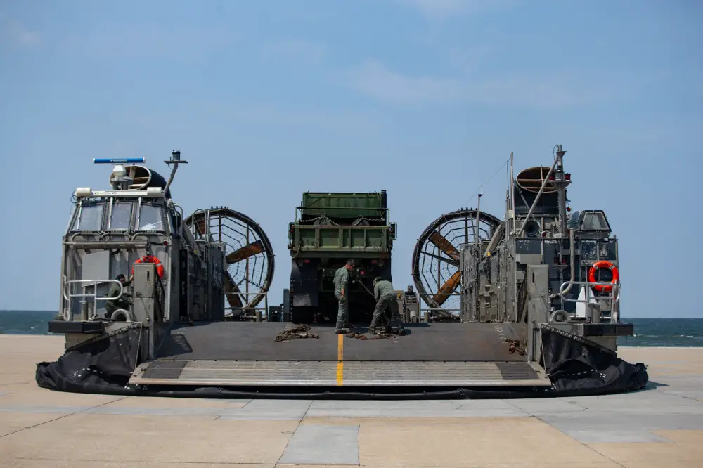 U.S. Navy Sailors unload tactical vehicles from an air cushion, landing craft onto a vehicle staging area during Defense Support of Civil Authorities (DSCA) mission rehearsals at Naval Base Norfolk, Virginia, July 22, 2021.