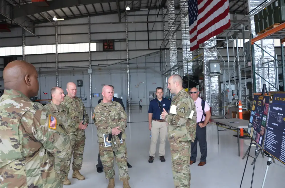 Lt. Col. Dan Thetford, right, Product Manager for the UH-60V Black Helicopter, provides an overview of the aircraft capabilities to Brig. Gen. Andy Chevalier, center, Land Component Commander, Rohde Island National Guard, and several state aviation officers at the Huntsville, Al. International Airport July 13.