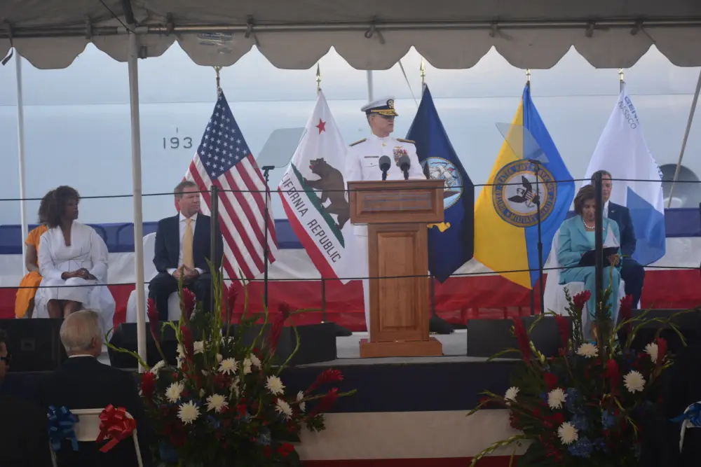 Rear Adm. Michael Wettlaufer, Commander, Military Sealift Command, speaks during the christening ceremony of the fleet replenishment oiler USNS John Lewis. Wettlaufer was one of several speakers at the event that also included House Speaker Nancy Pelosi (right) and actress and activist Alfre Woodard Spenser (left).