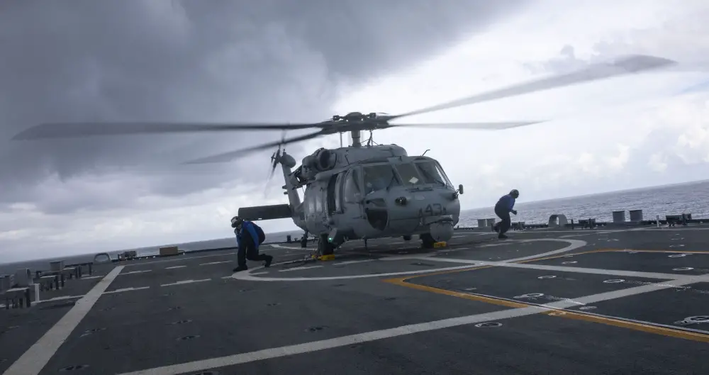 Sailors attach chocks and chains to an MH-60S Sea Hawk helicopter assigned to Helicopter Sea Combat Squadron (HSC) 28 Detachment Five during flight quarters aboard the Freedom-variant littoral combat ship USS Billings (LCS 15). 