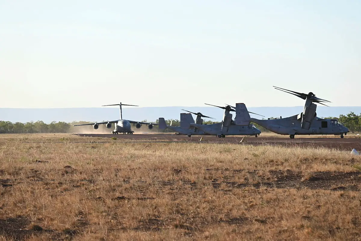 Royal Australian Air Force Boeing C-17A Globemaster III prepares for takeoff at Nackaroo Airfield, Bradshaw Field Training Area near three United States Marine Corps MV-22B tilt rotor aircraft as part of Exercise Loobye.