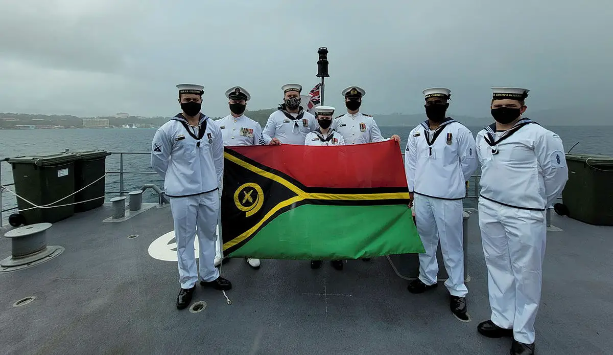 Able Seaman Boatswain's Mate Marcus Dawson, Petty Officer Boatswains Stephen Harvey, Leading Seaman Naval Police Coxswain Jack Williams, Leading Seaman Communications and Information Systems Kiani Hughes, Commanding Officer of HMAS Glenelg Lieutenant Commander LCDR Alexander Finnis, Able Seaman Boatswain's Mate Ebrahim Dollie, Able Seaman Marine Technician Christopher Barnett display the Vanuatu National Flag in celebration of Vanuatu's Independence Day while at anchor in Port Vila Harbour. 