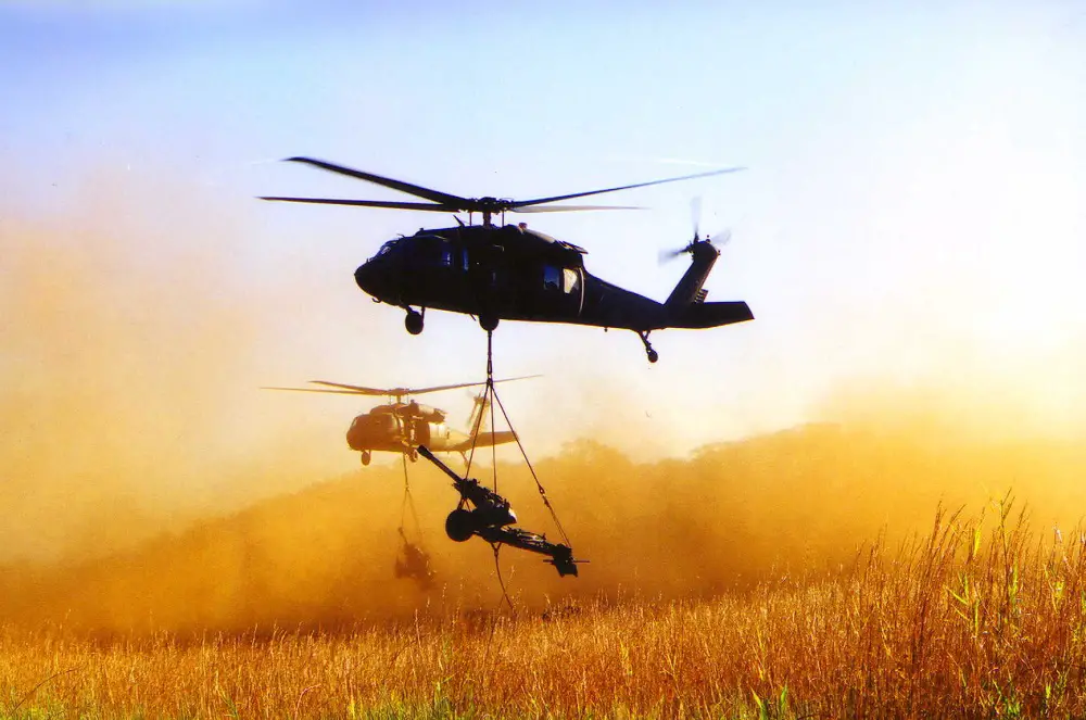 M119A1 light towed howitzer slingloaded by UH-60 Blackhawk Helicopters
