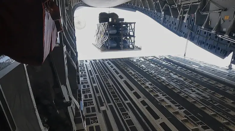 A standard cargo airdrop of the Palletized Munition Deployment System from a C-17A. A 4-pack configuration is used for demonstration purposes.