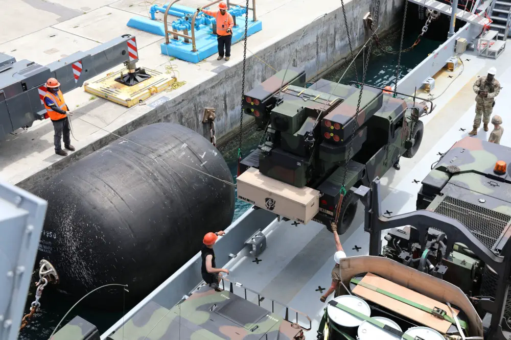 Soldiers of the 97th Transportation Company, 7th Sustainment Brigade, and civilian contract workers load an Avenger Air Defense System assigned to 1st Battalion, 174th Air Defense Artillery Regiment onto an Army Watercraft System in support of exercise Forager 21 on July 28, 2021, Naval Station Guam. 