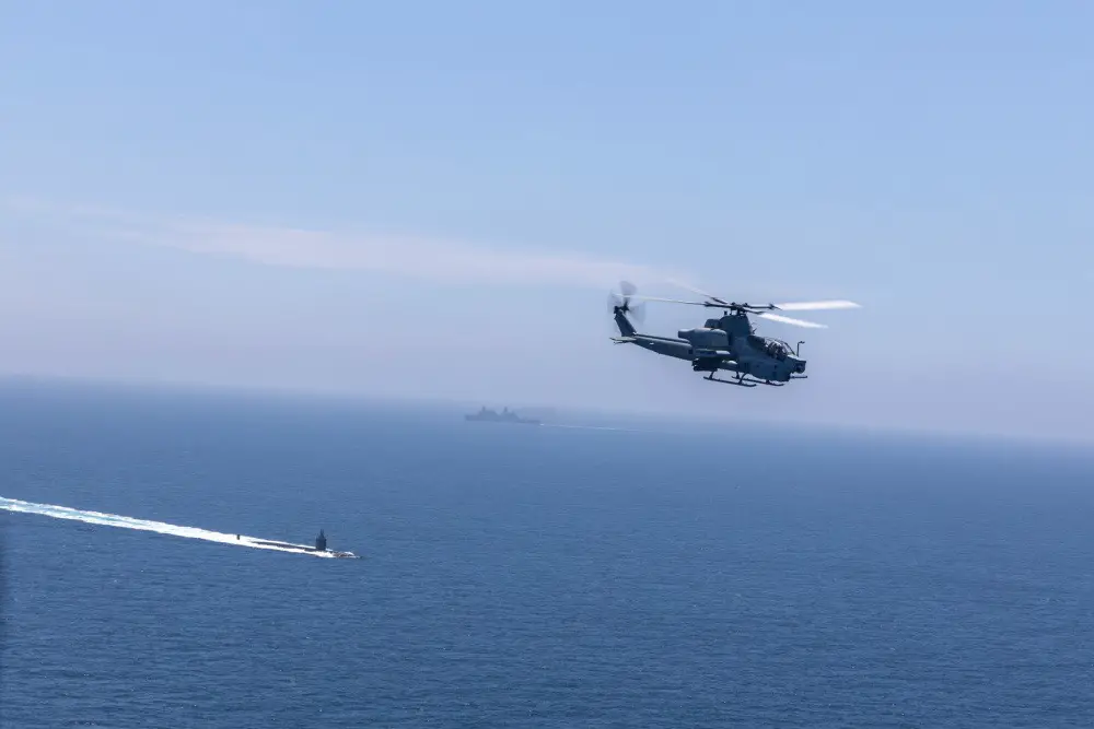 An AH-1Z Viper with Marine Light Attack Helicopter Squadron 267, Marine Aircraft Group 39, 3rd Marine Aircraft Wing (MAW), flies past a U.S. Navy Destroyer and Submarine during the Advanced Naval Basing evolution of Summer Fury 21 at San Clemente, California, July 20, 2021.