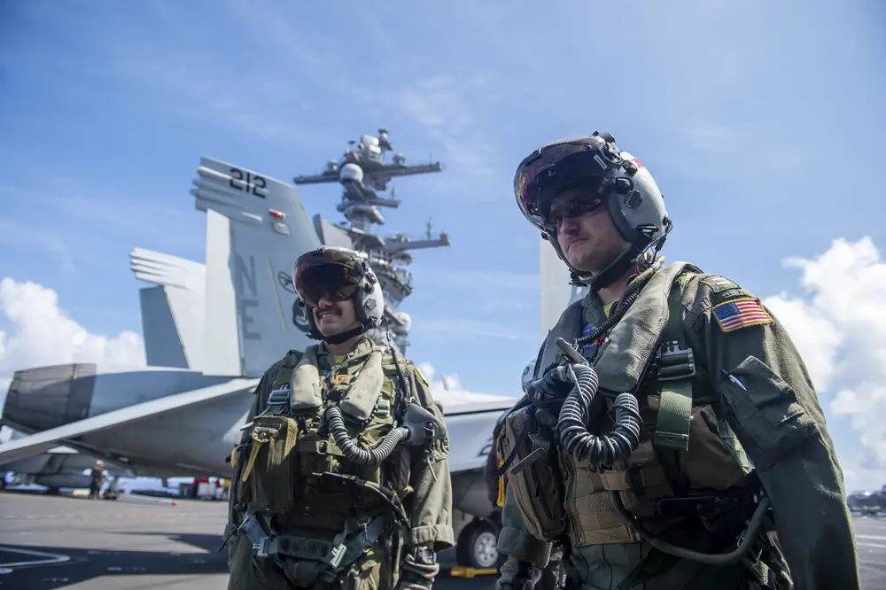 Pilots assigned to the Bounty Hunters of Strike Fighter Squadron (VFA) 2 prepare to enter an F/A-18F Super Hornet from the flight deck of Nimitz-class aircraft carrier USS Carl Vinson (CVN 70), Aug. 26, 2021.