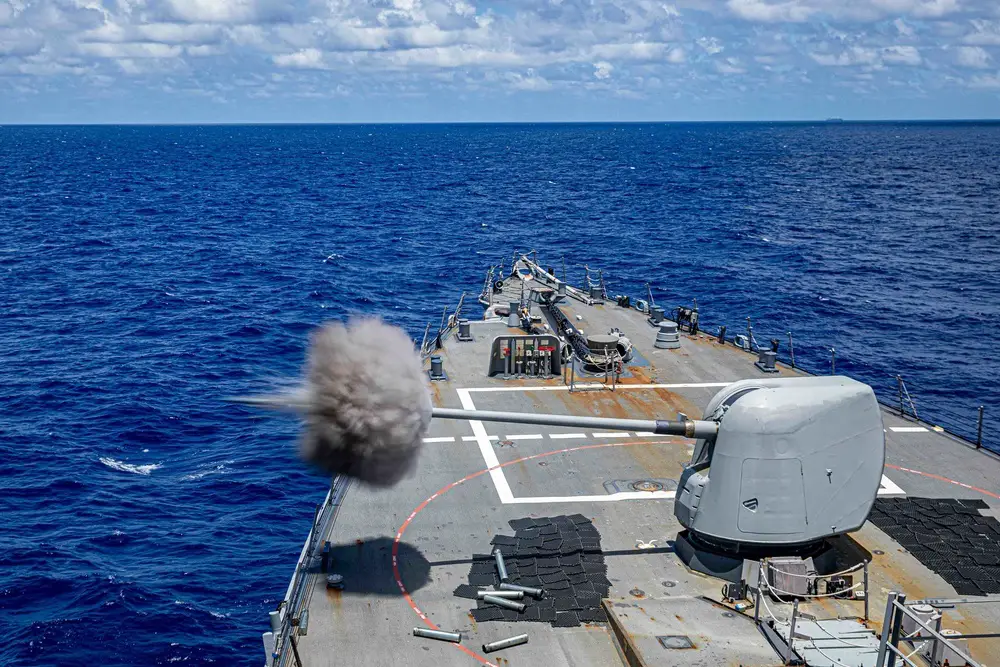  The Arleigh Burke-class guided-missile destroyer USS Curtis Wilbur (DDG 54) fires a 5-inch gun during a gunnery exercise. Curtis Wilbur is assigned to Commander, Task Force 71/Destroyer Squadron (DESRON) 15, the Navy’s largest forward DESRON and the U.S. 7th Fleet’s principal surface force.