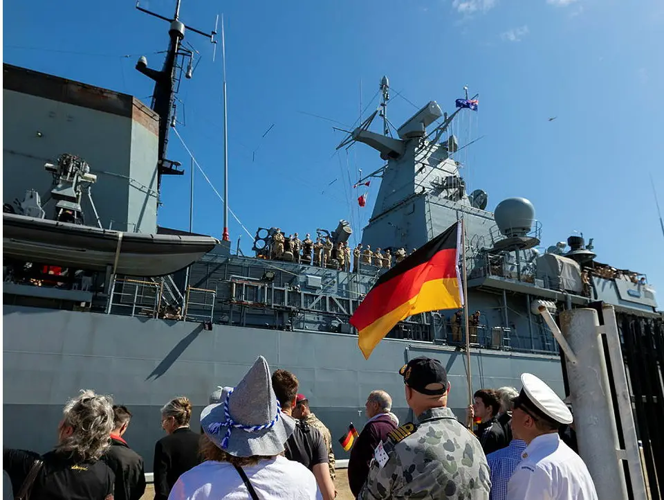 The crew of German Navy frigate FGS Bayern are greeted by the Commanding Officer of HMAS Stirling, Captain Gary Lawton RAN (second right) Chief Petty Officer Boatswain Dale Hofman and well-wishers on arrival into the Port of Fremantle in Western Australia.