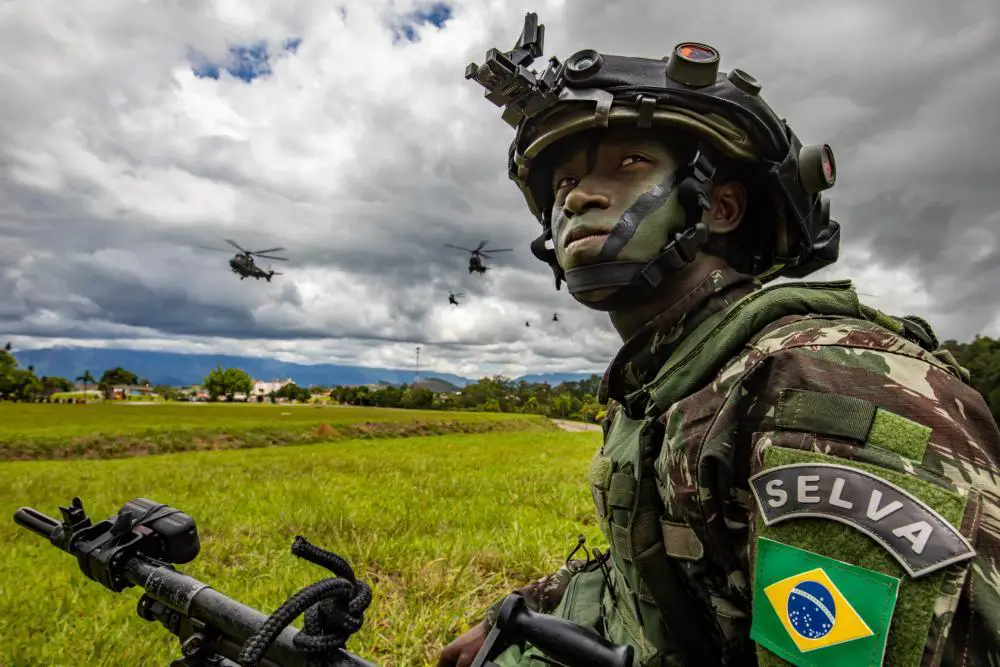 A Brazilian army soldier assigned to 5th Battalion, 12th Light Infantry (Air Assault), 2nd Division, kneels in the grass during Southern Vanguard 22 in Lorena, Brazil, Dec. 7, 2021. U.S. and Brazilian army soldiers took part in the air assault exercise, which was the largest deployment of a U.S Army unit to train with the Brazilian army forces in Brazil. 