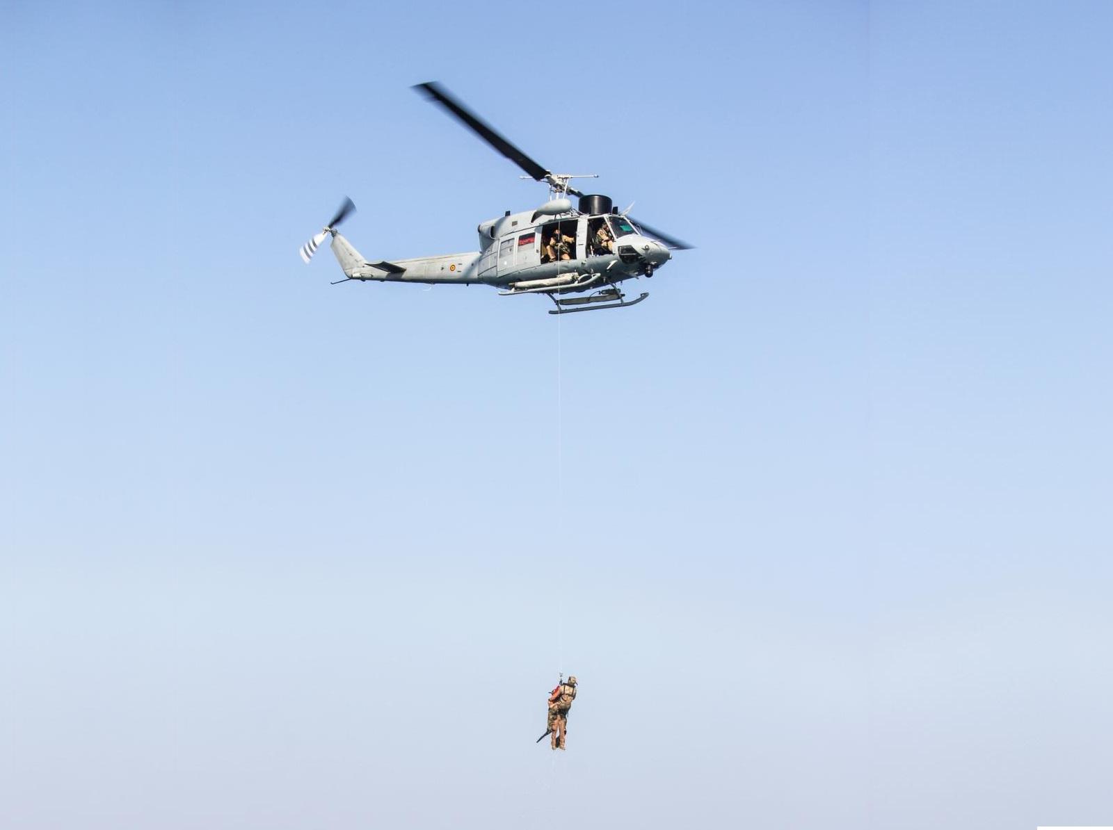 A U.S. Air Force pararescueman, assigned to the 82nd Expeditionary Rescue Squadron and a simulated rescued individual are hoisted into a Spanish AB-212 helicopter during Exercise Bull Shark over the Gulf of Aden near Djibouti, Dec. 3, 2021.