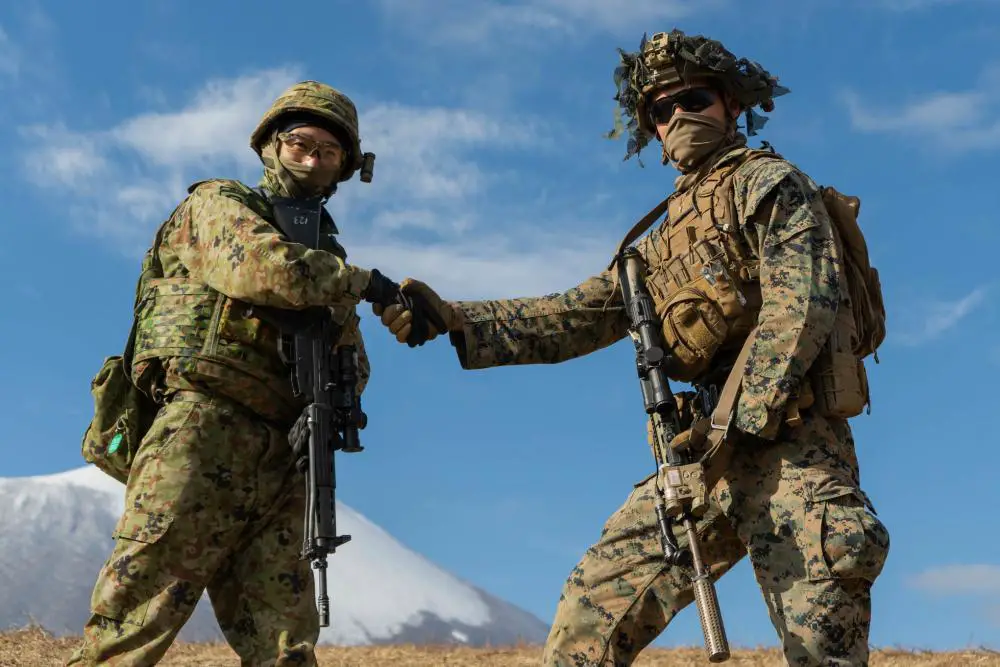 Japan Self-Defense Force soldier Pfc. Daik Kudo and U.S. Marine Corps Cpl. Wesley Nevin, a rifleman with 2d Battalion, 8th Marines, shake hands before a shooting competition during Resolute Dragon 21 at Iwate, Japan, Dec. 9, 2021. 
